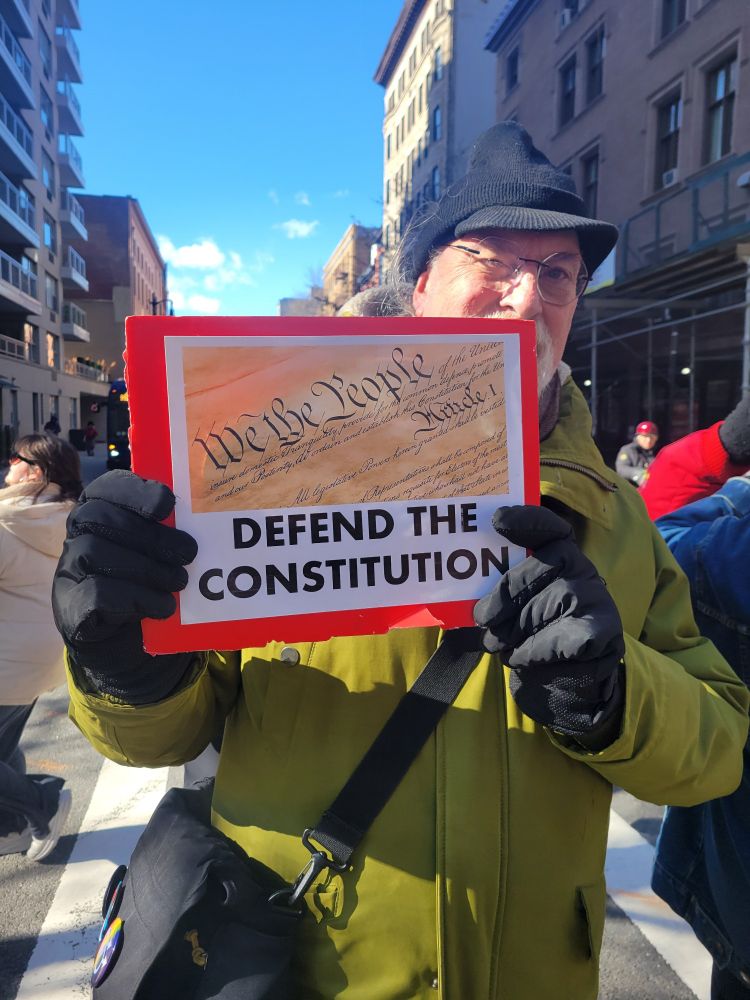 A sign that reads "We the people defend the constitution."