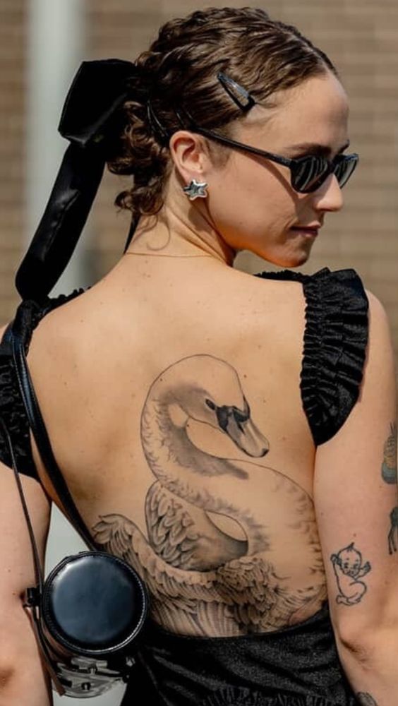A picture of Ella Emhoff showing off an intricate swan back tattoo.