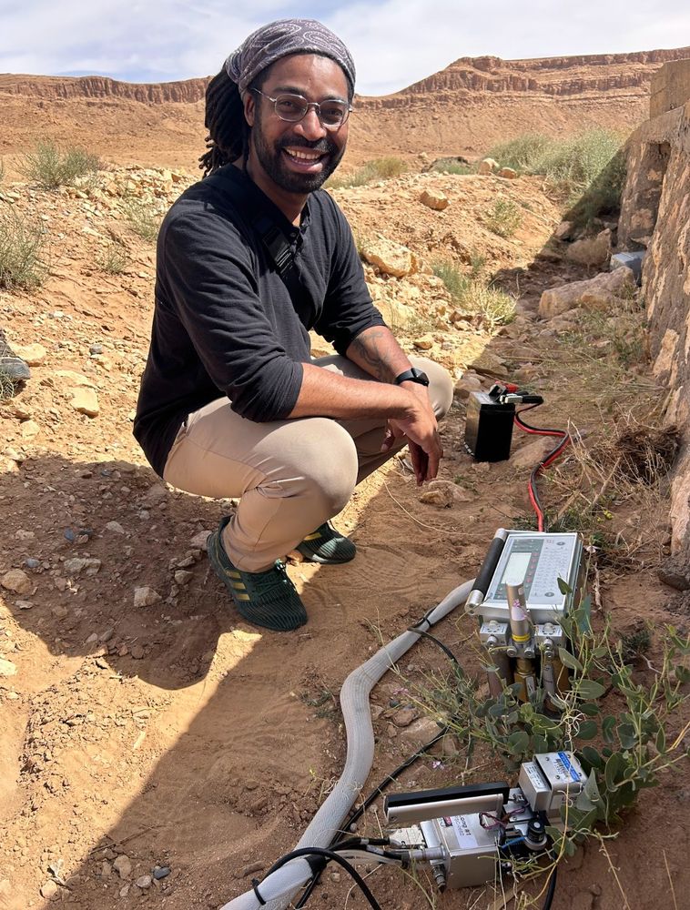 Afro-Caribbean researcher R. Shawn Abrahams in the Moroccan desert, measuring the photosynthetic capacity of the plant Moricandia suffruticose, a relative of Brassica crop plants like Broccoli. 