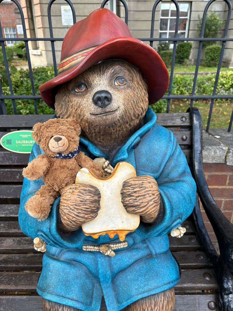 Ein Plüsch-Bär sitzt auf dem Arm der Statue des Kult-Bären „Paddington“ auf einer Bank in Salisbury.