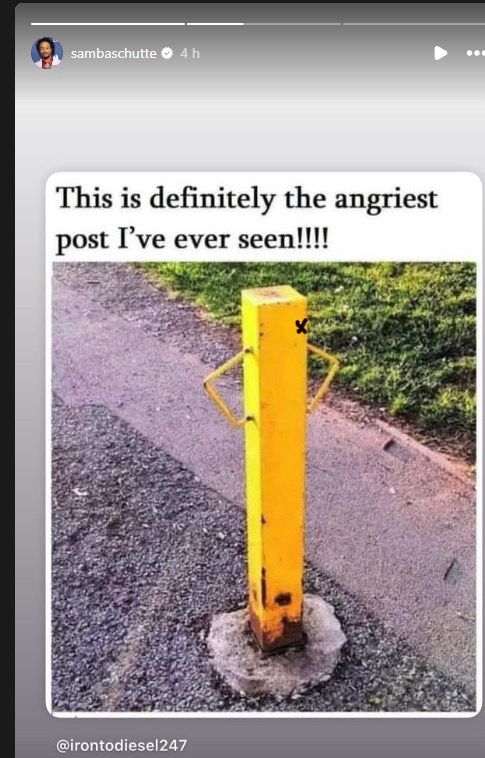 A yellow post sunk into cement in the ground, with wires that makes it look like it's got its hands on its hips, and with a tiny X to represent Izzy Hands.