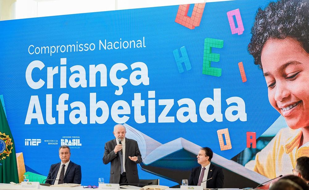 Presidente Lula falando, em pé, durante a reunião de Compromisso Nacional Criança Alfabetizada. Ao seu lado os ministros Camilo Santana e Rui Costa.