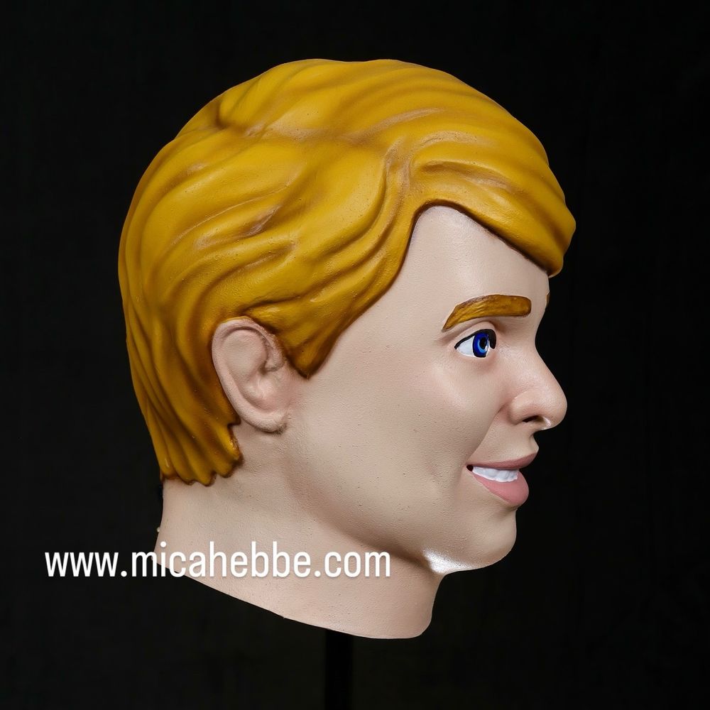 Male doll/action figure style mask. Blonde hair, blue eyes. Side view