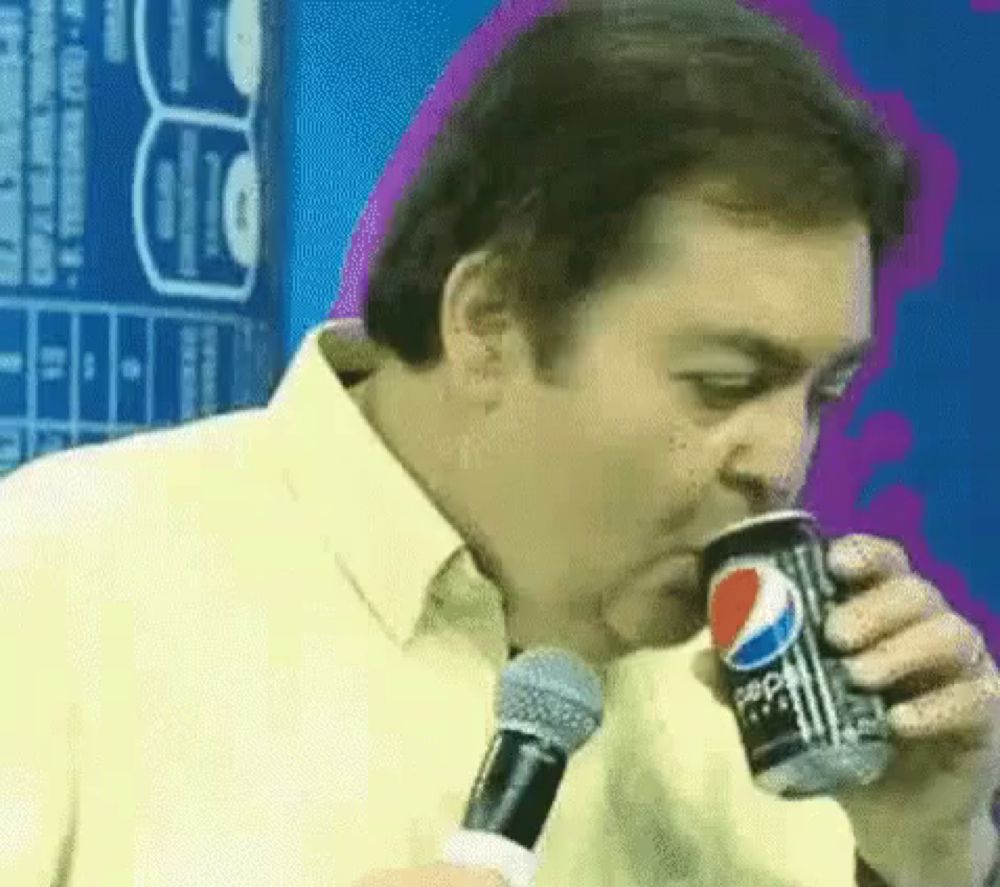 a man is drinking a can of pepsi from a microphone