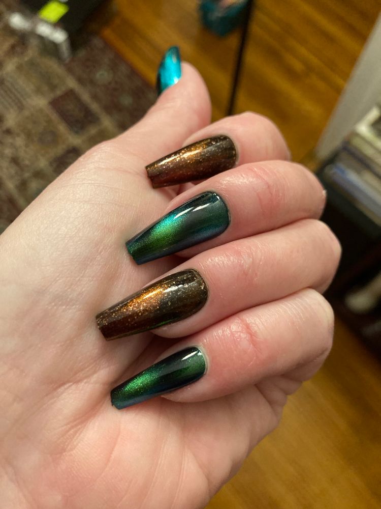 Catseye magnetized effect manicure alternating green/black and a rust/black with gold glittering chunks.