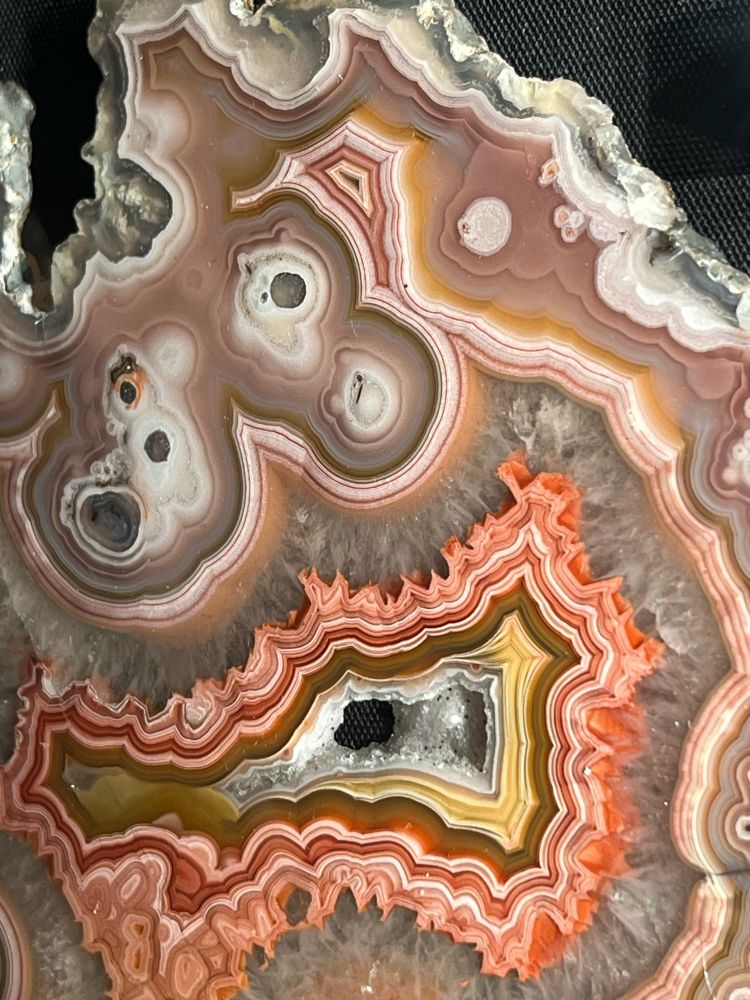 Swirly and bubbly patterns in brown, white, orange and yellow on a polished surface of an agate rock. (c) Lena Struwe. 