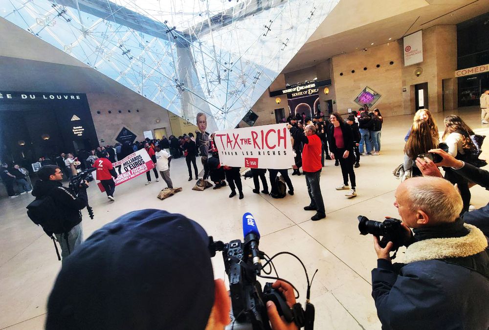 Photo de l'action d'Attac et de 350 devant l'AG de LVMH pour appeler à mieux taxer les riches.
