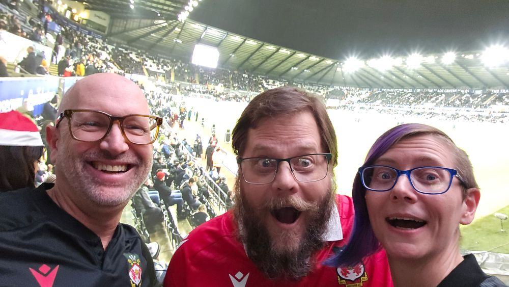 Three Wrexham fans in front of the wrap around screen at Cosm LA