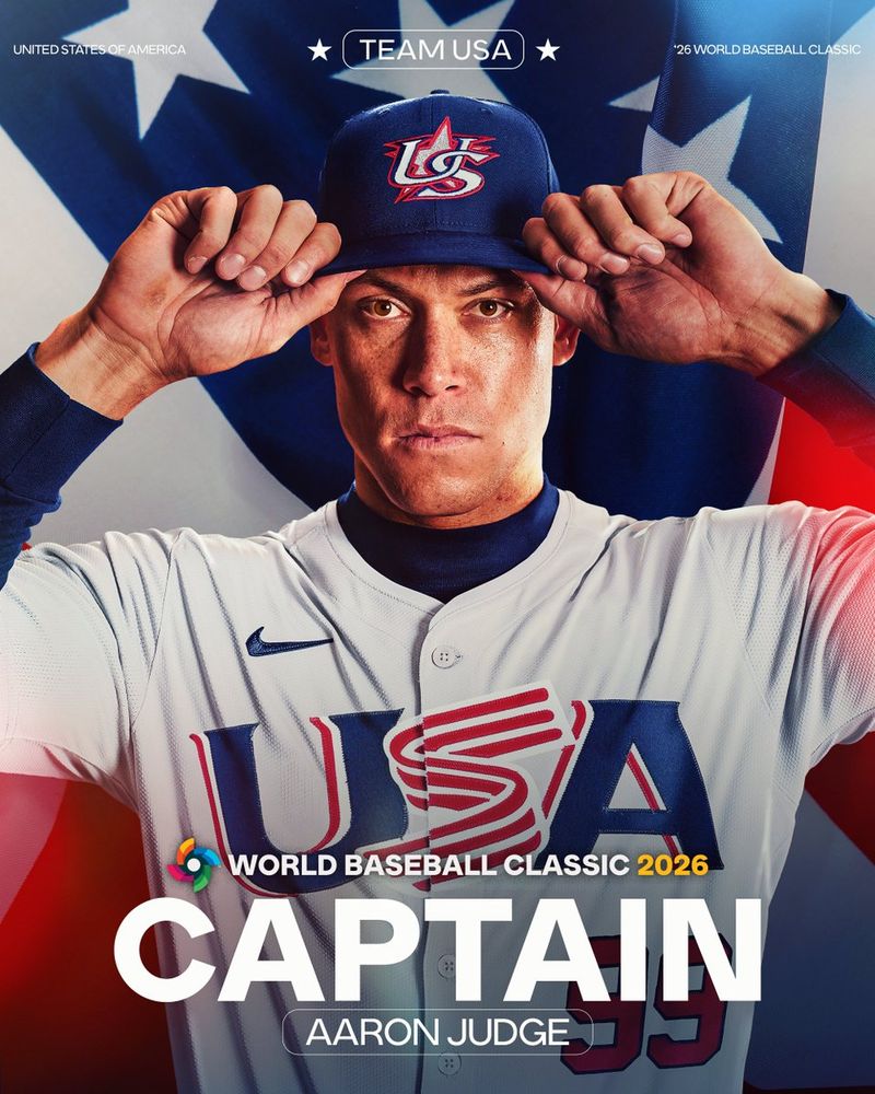 Team USA
2026 World Baseball Classic 
Captain 
Aaron Judge

Pictured: Aaron Judge wearing a photoshopped Team USA jersey featuring red, white, and blue lettering and a red No. 99, as well as a dark blue Team USA cap. Judge is pulling on the brim of the cap with both hands. 