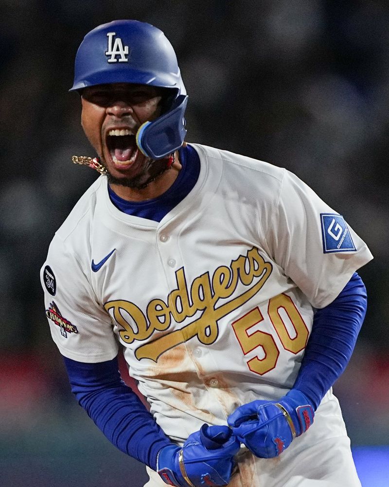 Mookie Betts screams in celebration after hitting a walk-off home run in the 10th inning. He wears a white Dodgers home uniform with gold lettering.