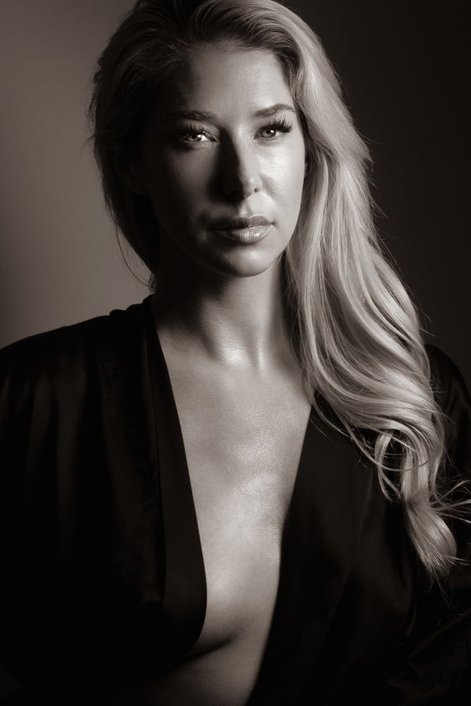 a boudoir themed portrait of a young french-canadian, american model in a semi shear black satin kimono