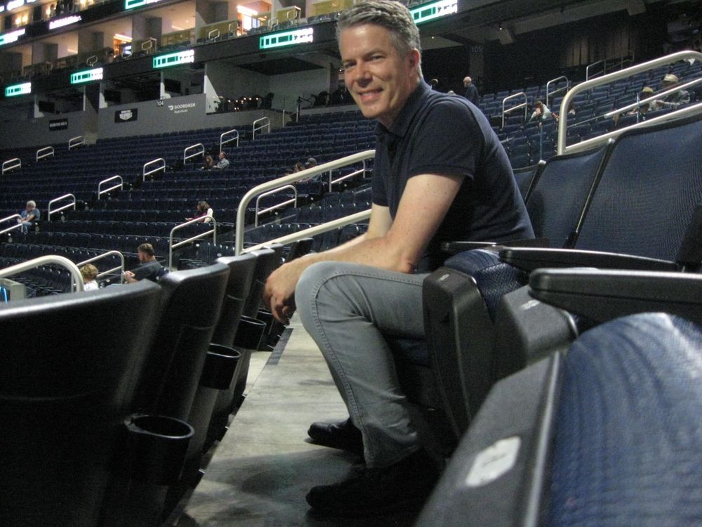 Man sitting in a nearly empty arena before a concert.