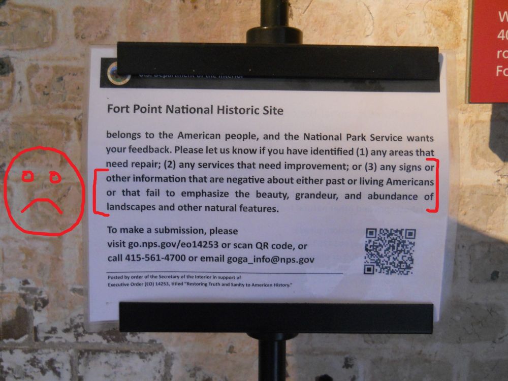 National Park sign urging people to report things they feel reflect American history in a negative light (plus my own added frowny face).