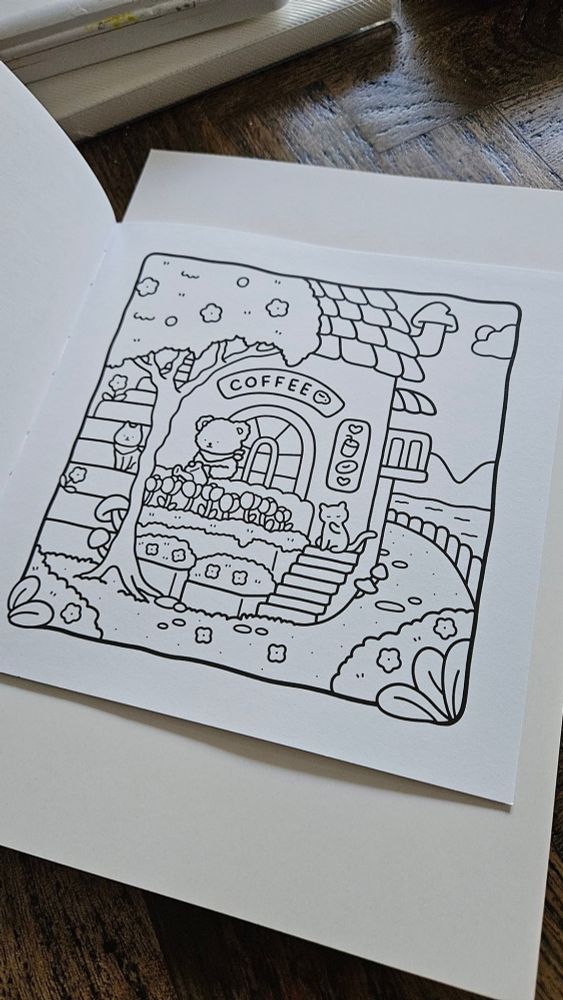 Uncolored page in a coloring book with a coffee shop and a bear