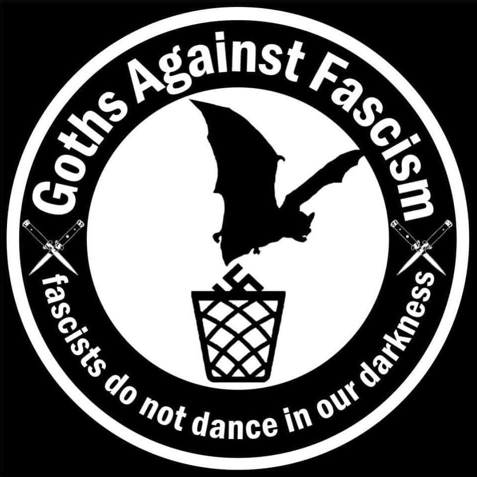 Circular logo with text "Goths Against Fascism - fascists do not dance in our darkness" and a bat throwing a swastika to a trashcan 