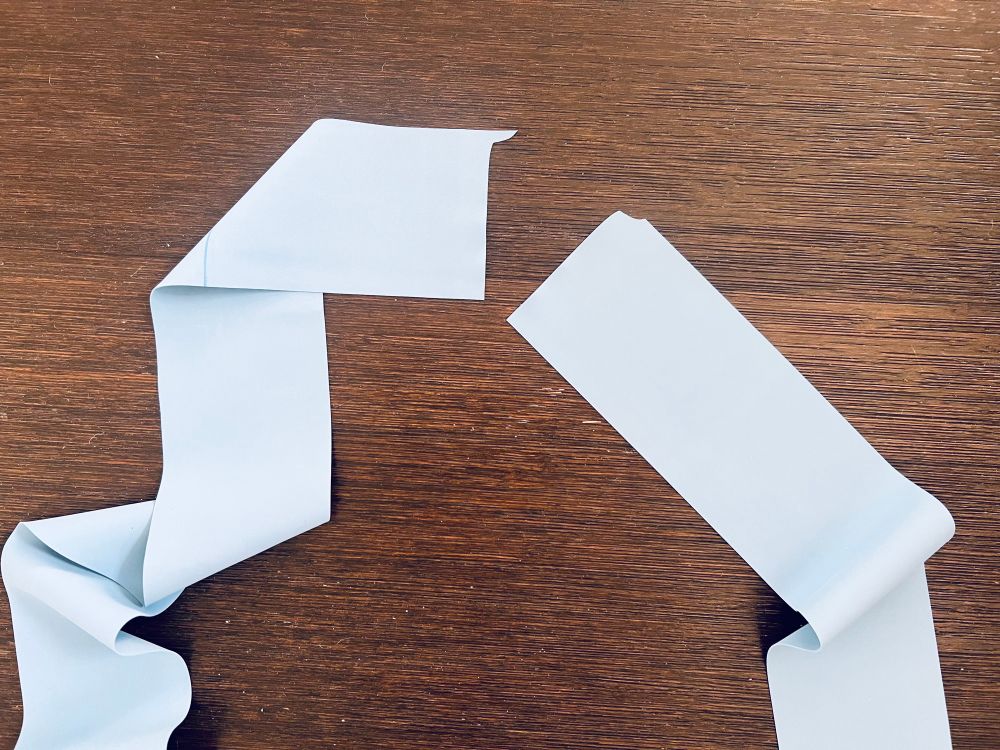 A pair of light blue exercise bands lay against a dark wooden floor. On reflection yes the bands are very thin and this was always going to happen okay I know. 