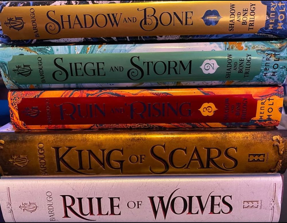 The spines of the hardcover editions of the three Shadow and Bone books and the two King of Scars books.