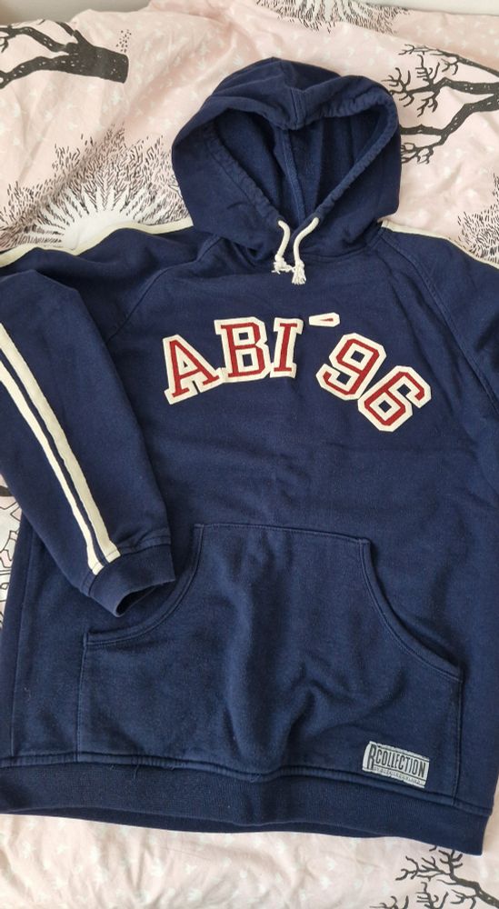 dark blue r collection hoodie with white stripes on the arm and text "abi '96" in big red and white letters on the chest.