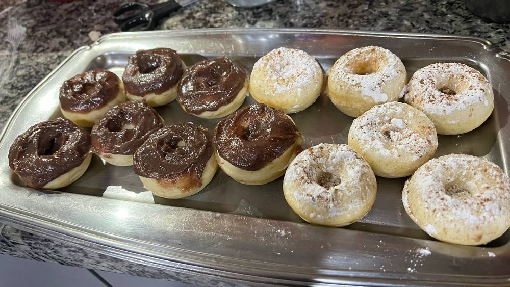 vários donuts com cobertura de açúcar e de brigadeiro numa bandeja
