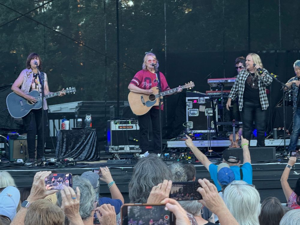 The Indigo Girls and Melissa Etheridge perform together on a stage in front of fans.