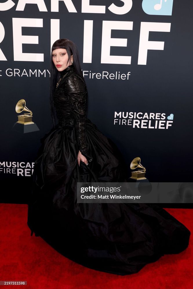Lady Gaga wearing a long black leather dress with short bangs and fierce long black hair on the red carpet at the Grammys 2025 Getty images credit: Matt Winkelmeyer 