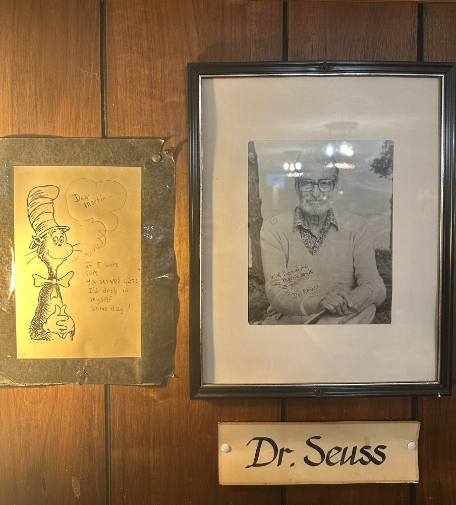 a framed photo of Dr. Seuss next to a signed picture of the cat in the hat, with an inscription reading "Dear Martin, if i knew you served cats I'd drop in myself someday". taken at The Traveler Restaurant, Union CT. 