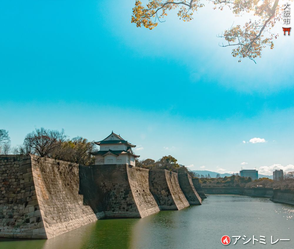 Views across the expansive grounds of Osaka Castle: from moss-covered stone walls and ancient turrets to garden paths and historic outbuildings set among green trees. | 大阪城の広大な敷地。苔むした石垣や古い櫓、緑の木々に囲まれた庭園の小路、歴史ある付属建物が点在する様子。