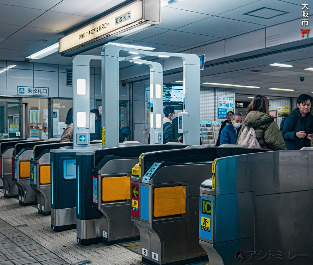 A row of fare gates at an Osaka subway station showing IC card readers, where commuters tap ICOCA cards to enter or exit. | 大阪の地下鉄駅、ICOCAカードをタッチして通れる自動改札機が並ぶ光景。