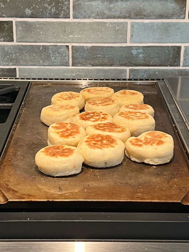 English muffins cooking on a griddle 