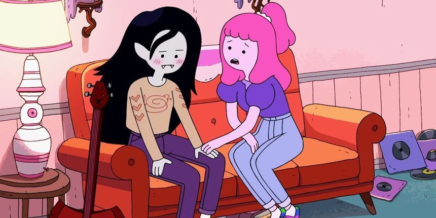 Marceline and Bubblegum from Adventure Time sitting on a couch. Marceline is looking down, blushing, and Bubblegum is talking to her with her hand on Marceline's and a mildly worried expression.