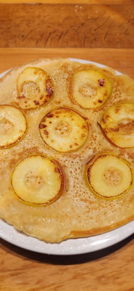 Ein großer Pfannkuchen mit gebratenen Apfelscheiben