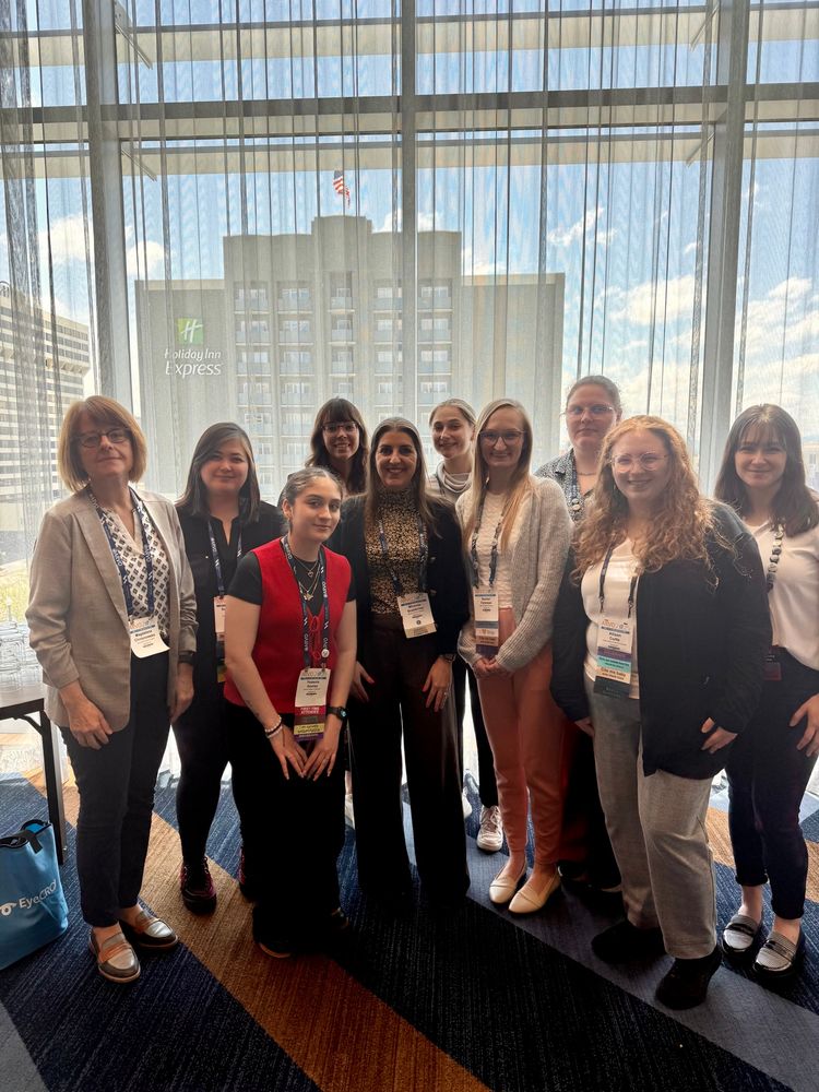 Ten women standing in front of a window