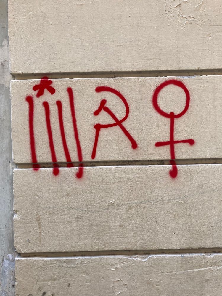 Simple but effective red spray paint symbols = four vertical lines with a wee star above them for the Catalan flag, hammer and sickle, woman symbol that’s a circle with a crossed line running from the bottom