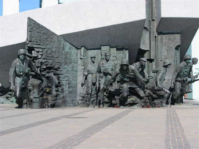 Denkmal zum Warschauer Aufstand in Warschau, Polen. Die monumentale Bronzeplastik zeigt polnische Widerstandskämpfer der Heimatarmee in dramatischer Pose beim Verlassen einer zerstörten Mauer und beim Hinabsteigen in die Kanalisation – ein Hinweis auf ihre Fluchtwege während des Aufstands 1944. Das Denkmal steht auf einem offenen Platz vor dem Museum des Warschauer Aufstands. (Bild: Wikimedia Commons)