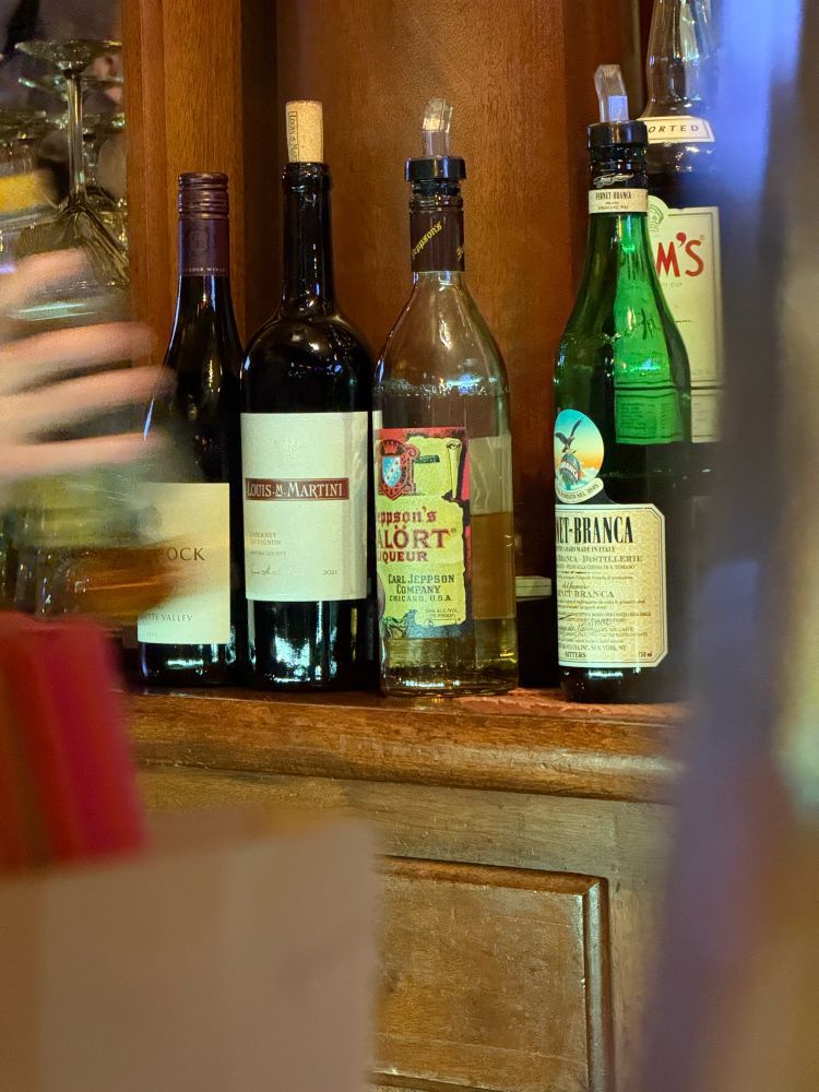 A bottle of Malort among other bottles on a bar back. 