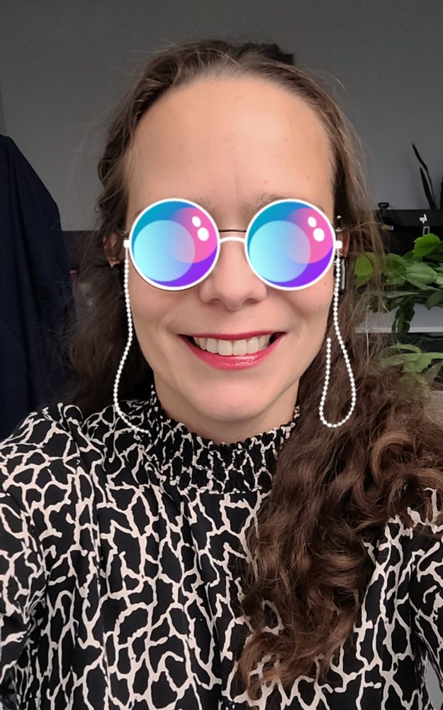 Selfie von mir,  ich lächle in die Kamera,  trage roten Lippenstift, die Haare halb offen und gewellt und ein schwarz-weißes Kleid