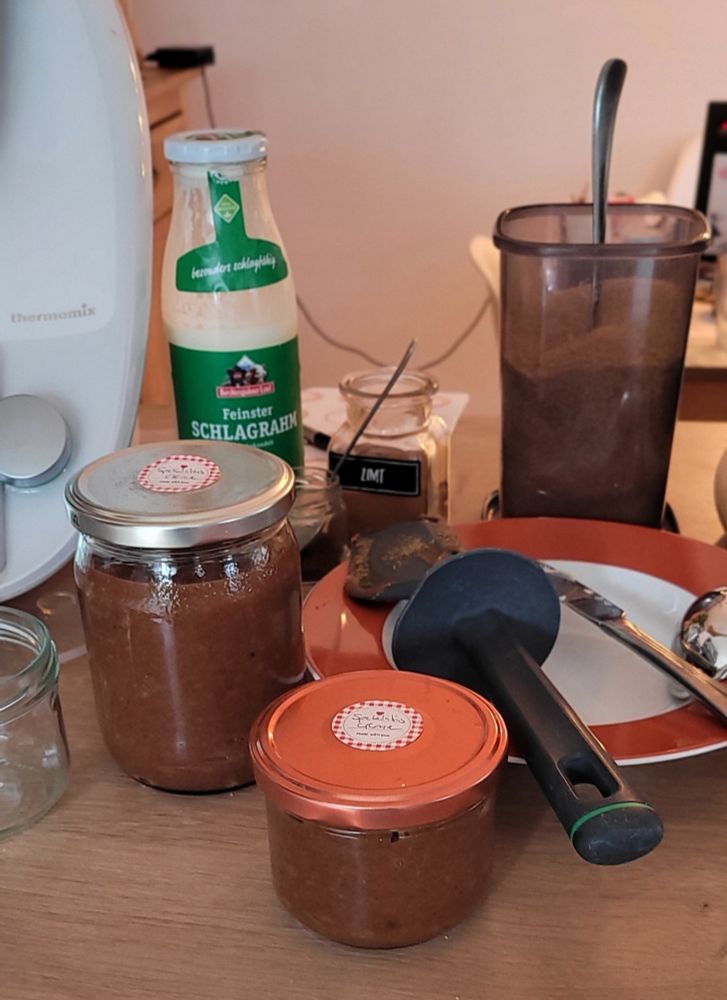 2 Gläser mit Spekulatiuscreme,  dahinter ein Teller mit verschiedenem Besteck, Zucker, Zimt  Sahne, daneben ein Thermomix 