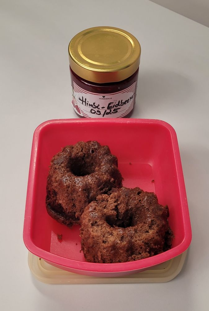 2 Mini Gugelhupf in einer Tupperdose, dahinter selbstgemachte Himbeer-Erdbeer-Marmelade