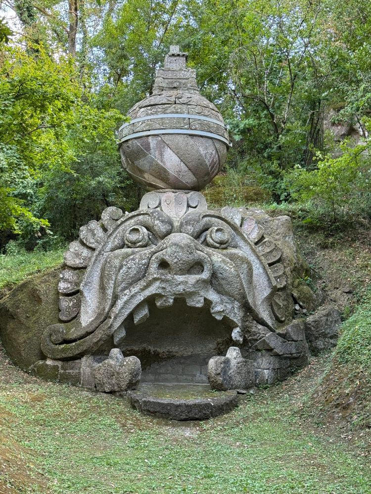 A giant stone carved monster face with mouth big enough to walk into & globe ontop