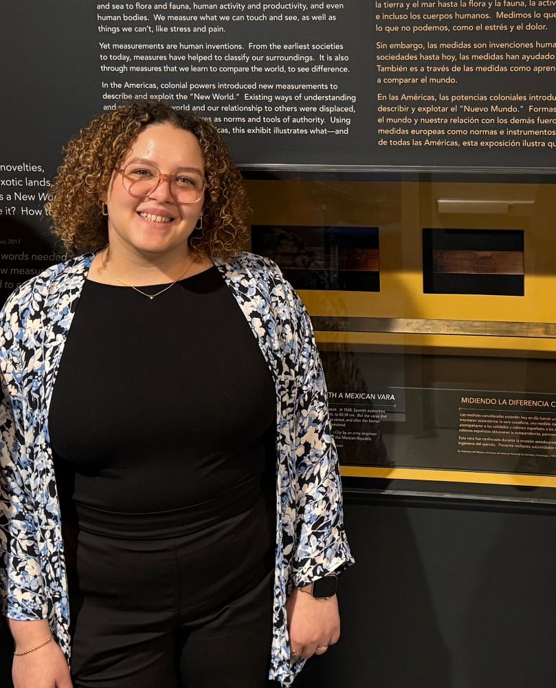Leticia smiling in front of a museum didplay