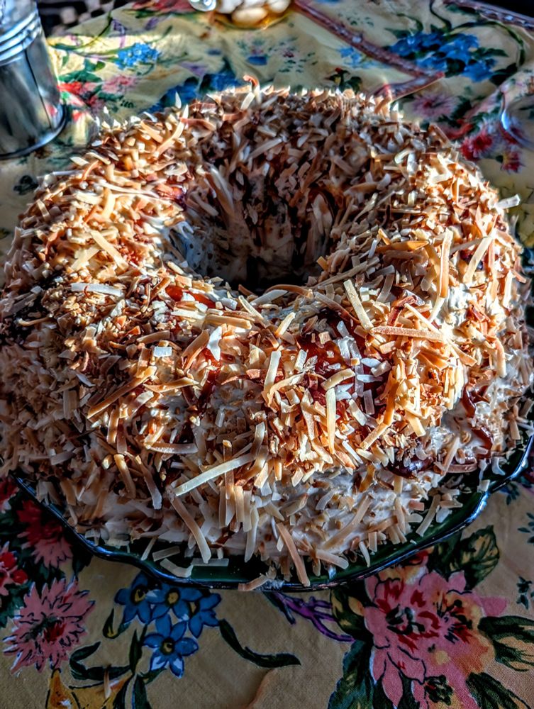 Coconut caramel Bundt cake on top of a floral table cloth in golden sunset light