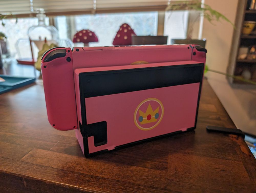 Back of my Nintendo Switch in its dock with the Lux Brand Minimalist Princess Peach Skin