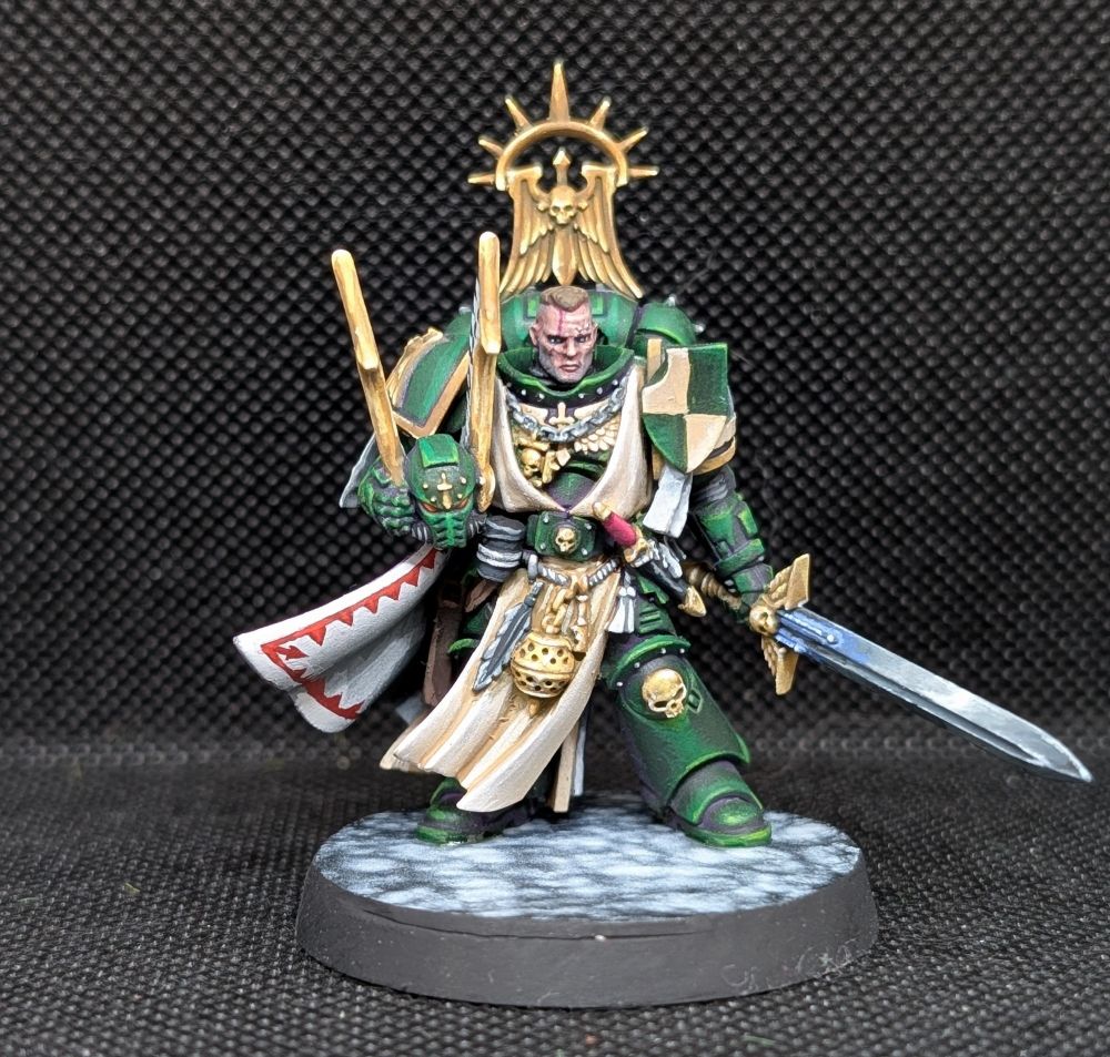 Dark Angels Master Lazarus from Games Workshop. 

His armour is dark green, the inside of his cloak is white with red trim. His sword is Non-metalic silver and the trim of his armour is non-metalic gold. He stands on a base painted like marble.

He poses with his helmet in his left arm and his sword in his right. 

Painted by me. 