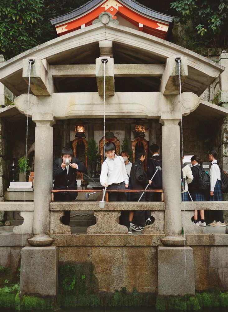 People cleansing themselves at a shrine water source 