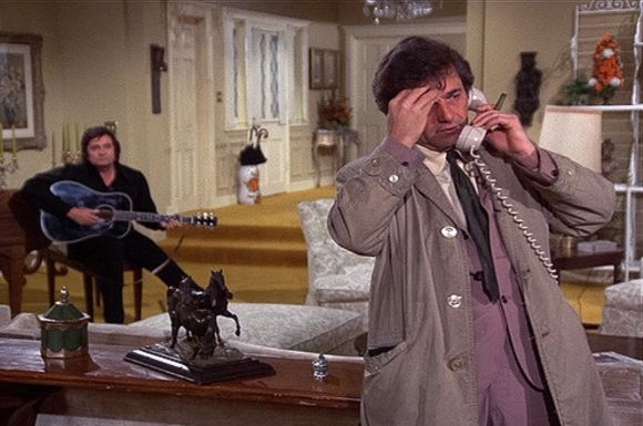 Johnny Cash playing guitar as Colombo takes a phone call