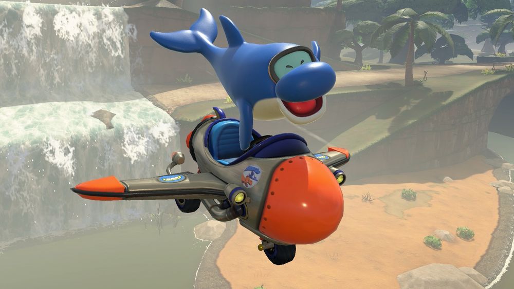 A screenshot of Mario Kart World with a character named Dolphin gliding on a kart over a savannah with a waterfall beneath them.