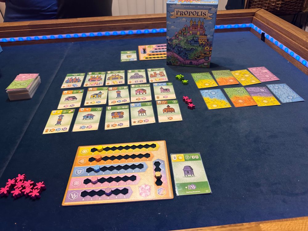 Game box, grid of cards, wood bee meeples.