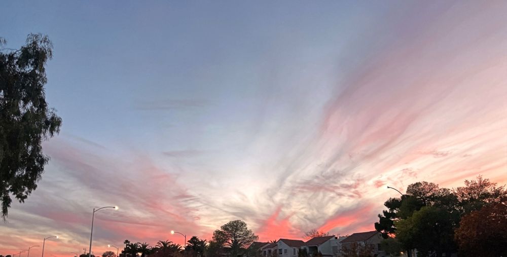 Colorful clouds above houses and trees