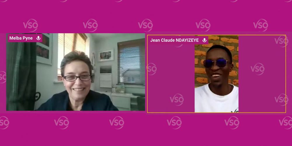 Volunteers Melba (left) and Claude (right) are seen in a split screen on a Zoom recording. The background is pink with the VSO logo fading in the background. Melba is in a home setting, wearing a black t-shirt and glasses. Claude is outdoors standing in front of a brick wall, also wearing glasses, and a white VSO t-shirt.