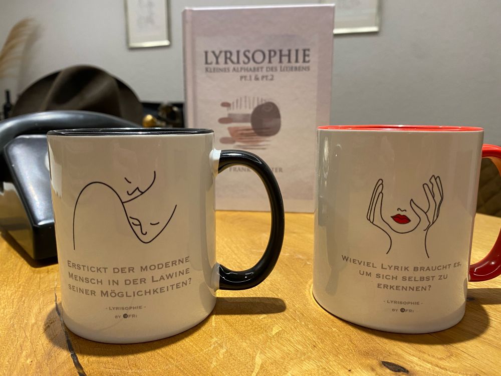 Gedichtband „Lyrisophie“ davor zwei Tassen mit schlichten Motiven und Spruch…!
